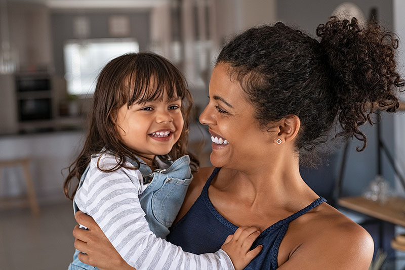 Healthy mom holding child and smiling